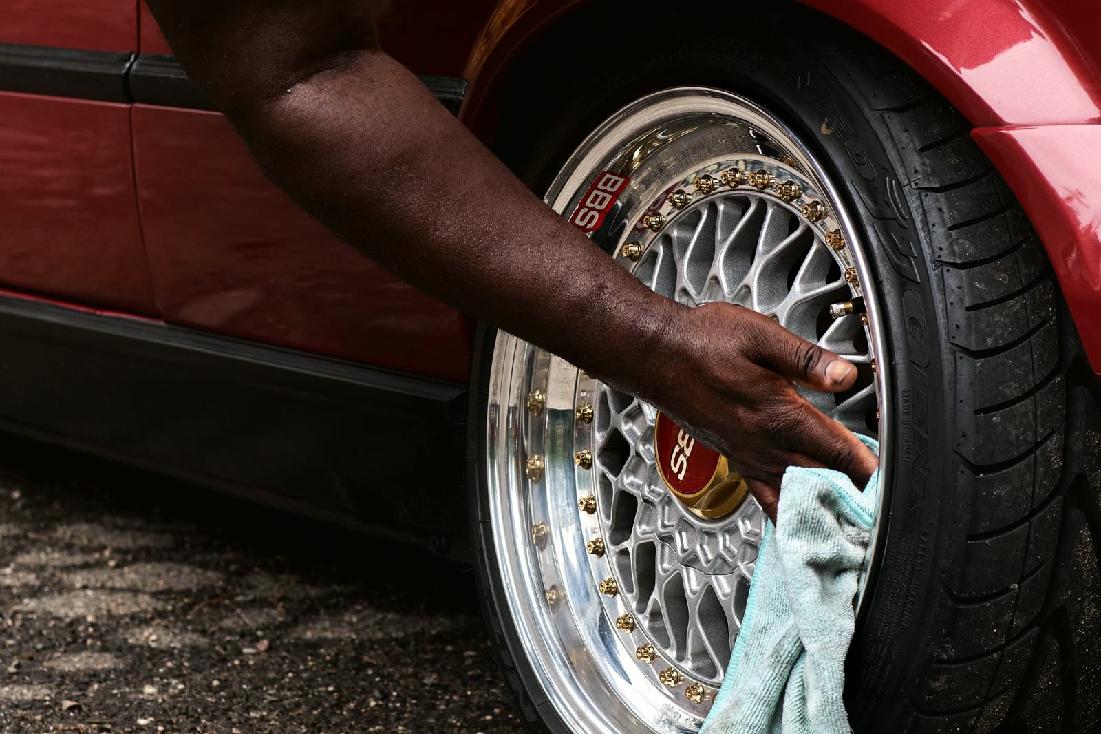 A detailer machine polishing a black car